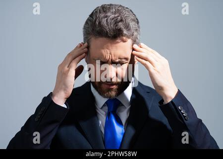 Headache, tiredness and stress. Business man in suit is tired got headache migraine. Headache pain concept. Painful men are stressed. Stressful and Stock Photo