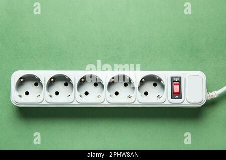 Electric extension cord on green background Stock Photo