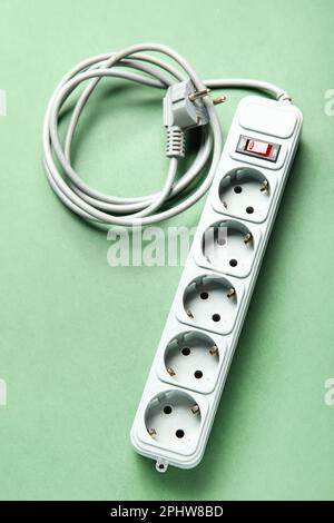 Electric extension cord on green background Stock Photo