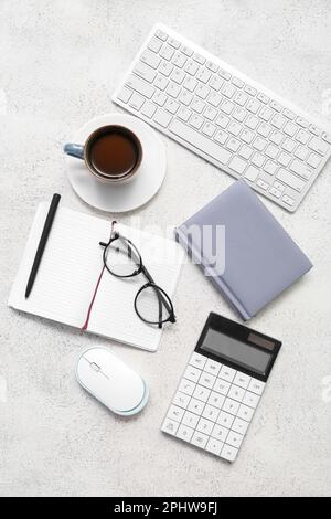 Composition with eyeglasses, blank notepad and coffee on light grunge background Stock Photo