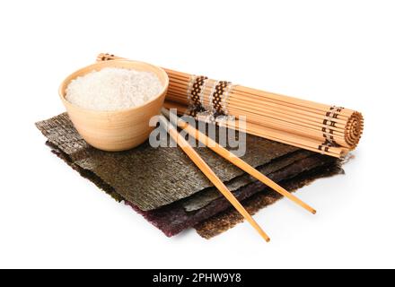 Natural nori sheets, chopsticks, bamboo mat and bowl of rice isolated on white background Stock Photo