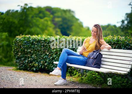 Ill wait for you at the park. a young woman relaxing in the park. Stock Photo
