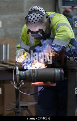 man soldering in a factory Stock Photo