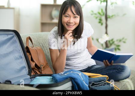 happy young traveller woman holding packing list Stock Photo