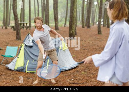 young couple paying badminton in a camping Stock Photo