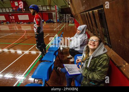 Non Skating Officials (NSOs) manage a roller derby penalty box where penalised skaters have to wait off track to serve out there penalty Stock Photo