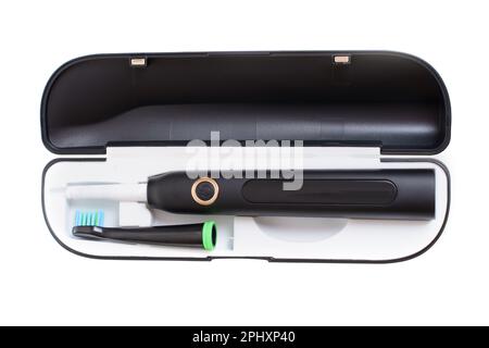 Close-up view of a black electric toothbrush with a detachable brush head, neatly placed inside a black and white travel case isolated on white backgr Stock Photo
