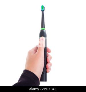 Close-up of a black and green electric toothbrush in hand isolated on white background. Stock Photo