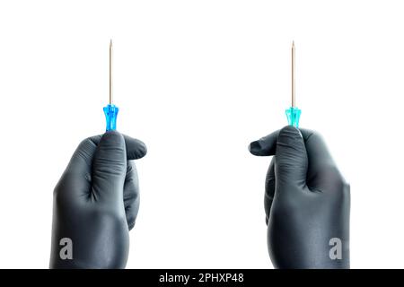 Black-gloved hands holding screwdrivers isolated on a clean white background. Creative repair and maintenance related concept. Stock Photo
