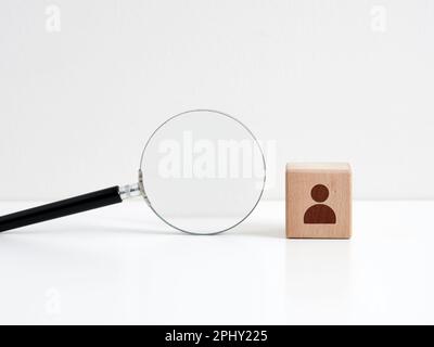 Searching for a talent or looking for employee concept. Human resources management. Recruitment and hiring. Wooden cube with employee icon and a magni Stock Photo