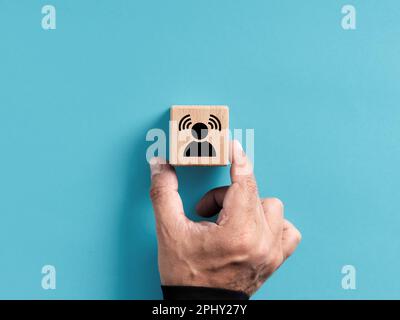 Brand awareness. Creating customer awareness in business marketing. Hand places the wooden cube with personal awareness icon. Stock Photo