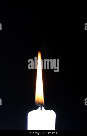 Burning white candle on a black background Stock Photo - Alamy
