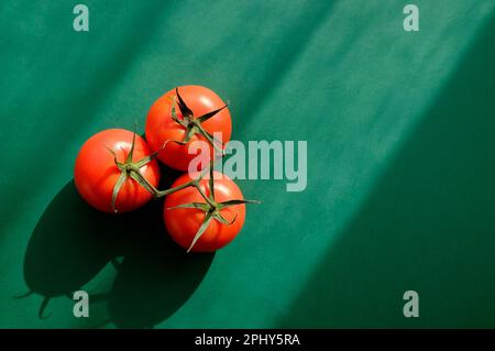 red tomatoes on green background Stock Photo