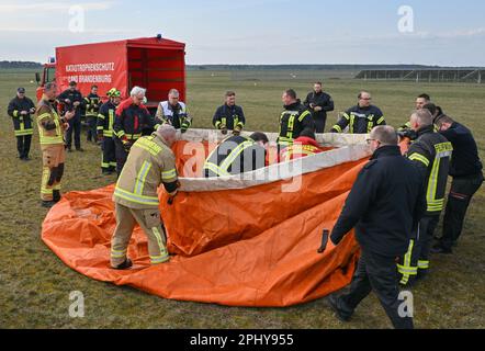 30 March 2023, Brandenburg, Müncheberg: Firefighters set up a mobile water extraction point during an exercise at Müncheberg-Eggersdorf airfield. On the same day, an exercise involving fire departments, the federal police and the German armed forces on fighting vegetation fires from the air took place at the airfield east of Berlin. The focus was on the practical use of air coordinators as a link between emergency forces in the air and on the ground. During the joint exercise, the fire departments practiced and deepened their interaction with the helicopter pilots of the Federal Police and the Stock Photo