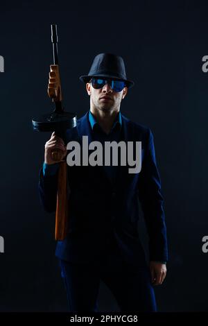 low key portrait of young gangster with hat in the darkness Stock Photo