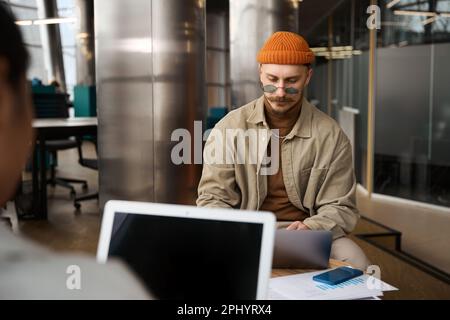 Two employees using their laptops in company office Stock Photo