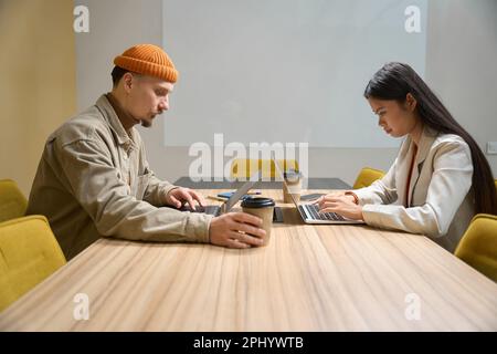 Office workers working on laptops in meeting room Stock Photo