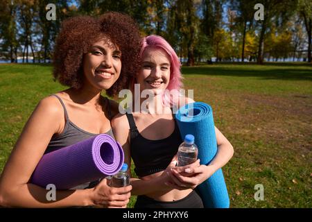 Smiling female athletes posing for camera after outdoor workout Stock Photo