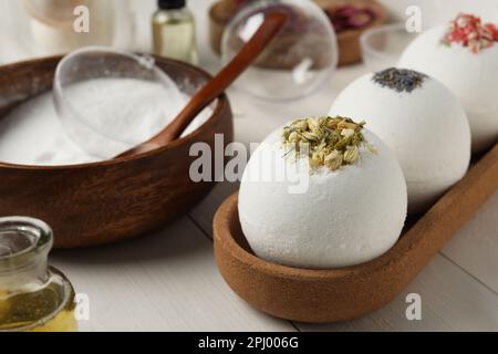 Different bath bombs and ingredients on white wooden table, closeup Stock Photo