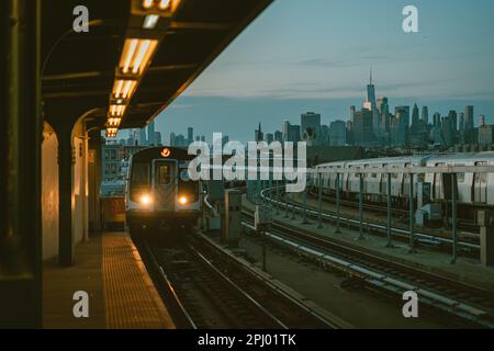 View of the Manhattan skyline and approaching subway train, at Smith-9th Streets station, Brooklyn, New York Stock Photo