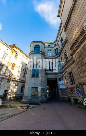 Wroclaw, Poland - June 2022: The facade of an old, dilapidated tenement house full of painted tags on a sunny afternoon Stock Photo
