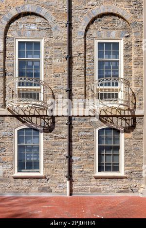 Stone facade with windows and balcony  of the campus of State University Stock Photo