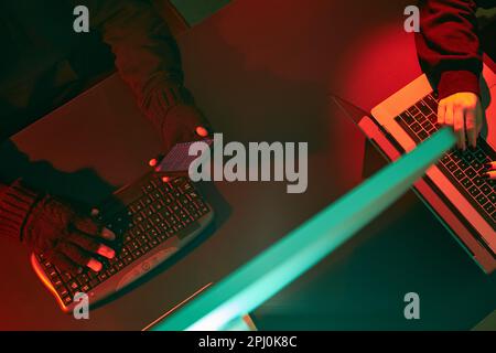 Anonymous people using computer and programming to break code. Cyber security threat. Internet and network security. Access to private information. An Stock Photo
