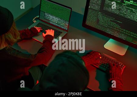 Anonymous people using computer and programming to break code. Cyber security threat. Internet and network security. Access to private information Stock Photo