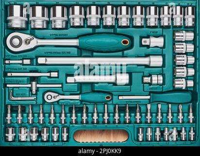 Ratchet with many attachments in plastic case. Work tools. Universal tool set. Background Stock Photo