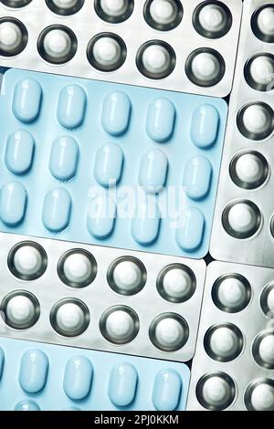 Tablets and capsules pill in blister packaging arranged in row. Medicines - tablets, pills in blister pack, medications drugs. Pharmaceutical industry Stock Photo