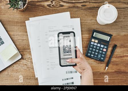 Woman paying for energy scanning QR code from bill. Making payment using QR scanner and fast secure payment system on smartphone. Business woman payin Stock Photo