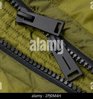 Double black matte zipper on bright green jacket. Close up detail Stock Photo