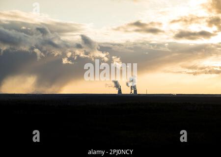A thermal power station with much smoke coming out of pipes with dark dramatic sky over it. Concept of air pollution. alternative energy and natural Stock Photo