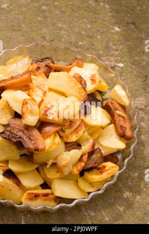 Crispy, ruddy fried potatoes with slices of fried lard on a large plate Stock Photo