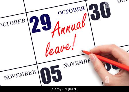 29th day of October. Hand writing the text ANNUAL LEAVE and drawing the sun on the calendar date October 29. Save the date. Time for the holidays. vac Stock Photo