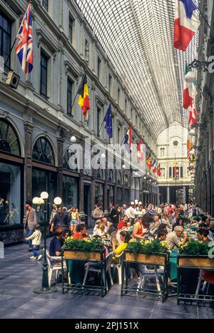 1993 HISTORICAL PEOPLE SEATED AT CAFES GALERIE DE LA REINE BRUSSELS BELGIUM Stock Photo
