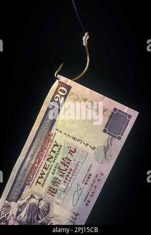 1994 HISTORICAL 20 HONG KONG DOLLAR BANK NOTE ON FISHING HOOK ON BLACK BACKGROUND Stock Photo