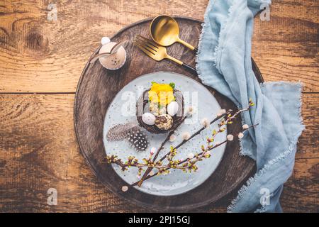 Easter table setting with spring flowers and cutlery on wooden table.  Spring Easter Holiday Table Stock Photo