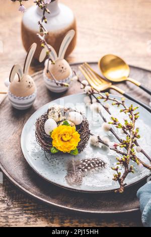 Easter table setting with spring flowers and cutlery on wooden table.  Spring Easter Holiday Table Stock Photo