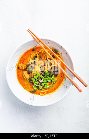 Thai red curry noodle soup with shiitake,  coconut milk and  green onions Stock Photo