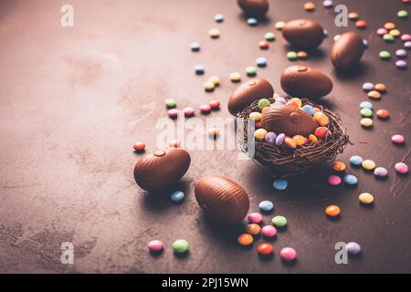 Sweet Easter - Chocolate eggs and colorful chocolate beans in bird nest Stock Photo