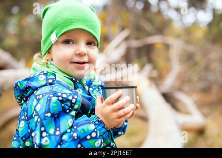 Father dad pours hot coffee tea from thermos into the mug on a family  picnic in the mountains. Child school boy kid is watching his dad filling  the Stock Photo - Alamy