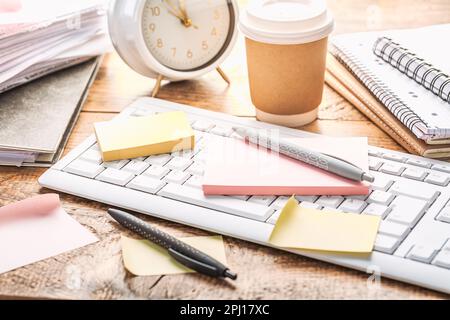 Time management concept. Composition with alarm clock on wooden table with laptop computer, stationary and post-it notes Stock Photo
