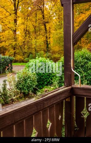 Old wooden terrace, damaged old wooden railing in a garden, weather-related damage Stock Photo