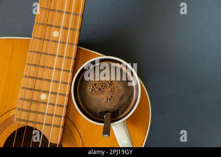 wooden guitar and a cup of coffee on a dark background Stock Photo