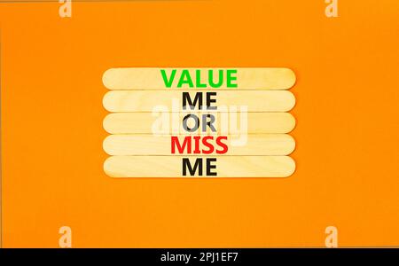 Value or miss me symbol. Concept words Value me or miss me on wooden stick. Beautiful orange table orange background. Business psychological and value Stock Photo