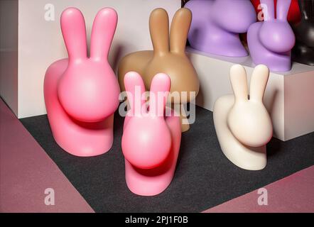 Easter bunnies in the form of large and small plastic figures of various colors. Sharing concept. Stock Photo