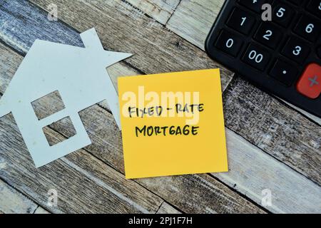 Concept of Fixed-Rate Mortgage write on sticky notes isolated on Wooden Table. Stock Photo