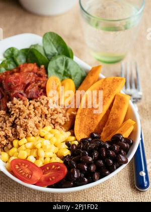 Sweet potato salad bowl with spinach, TVP, corn, black beans, tomato salsa and cherry tomatoes
