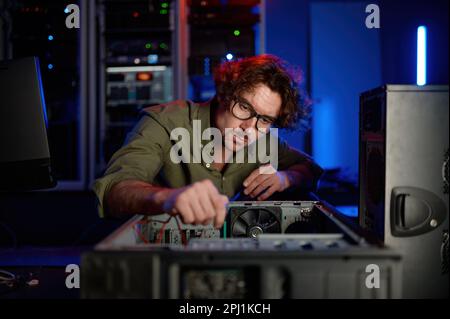 Man repairing computer system unit in modern service center Stock Photo